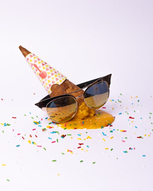 A cone with sunglasses and confetti on it