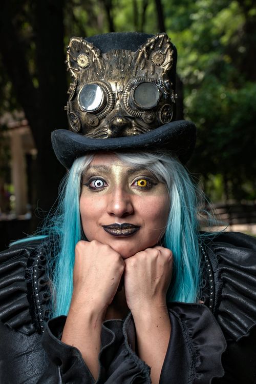 Free Vibrant portrait of a young steampunk cosplayer in an ornate costume with a top hat and bright hair. Stock Photo