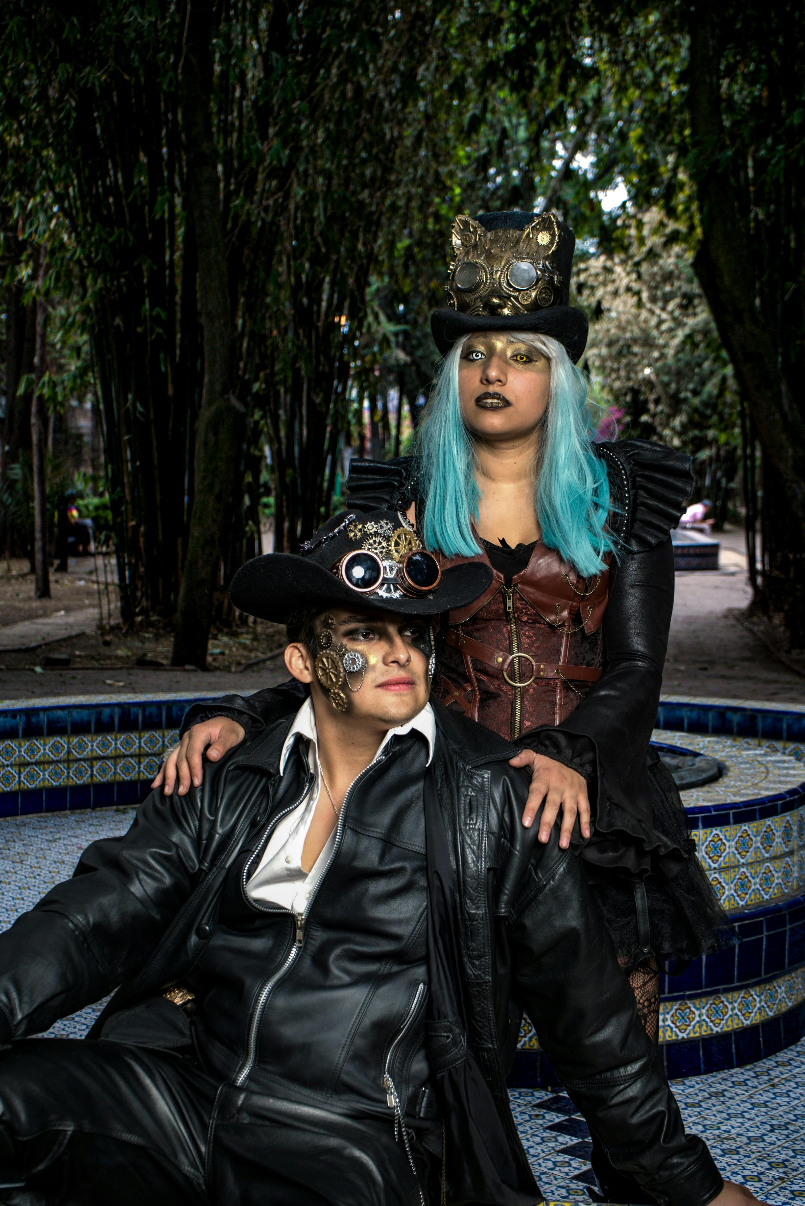 two steampunk cosplayers sitting on a fountain wall