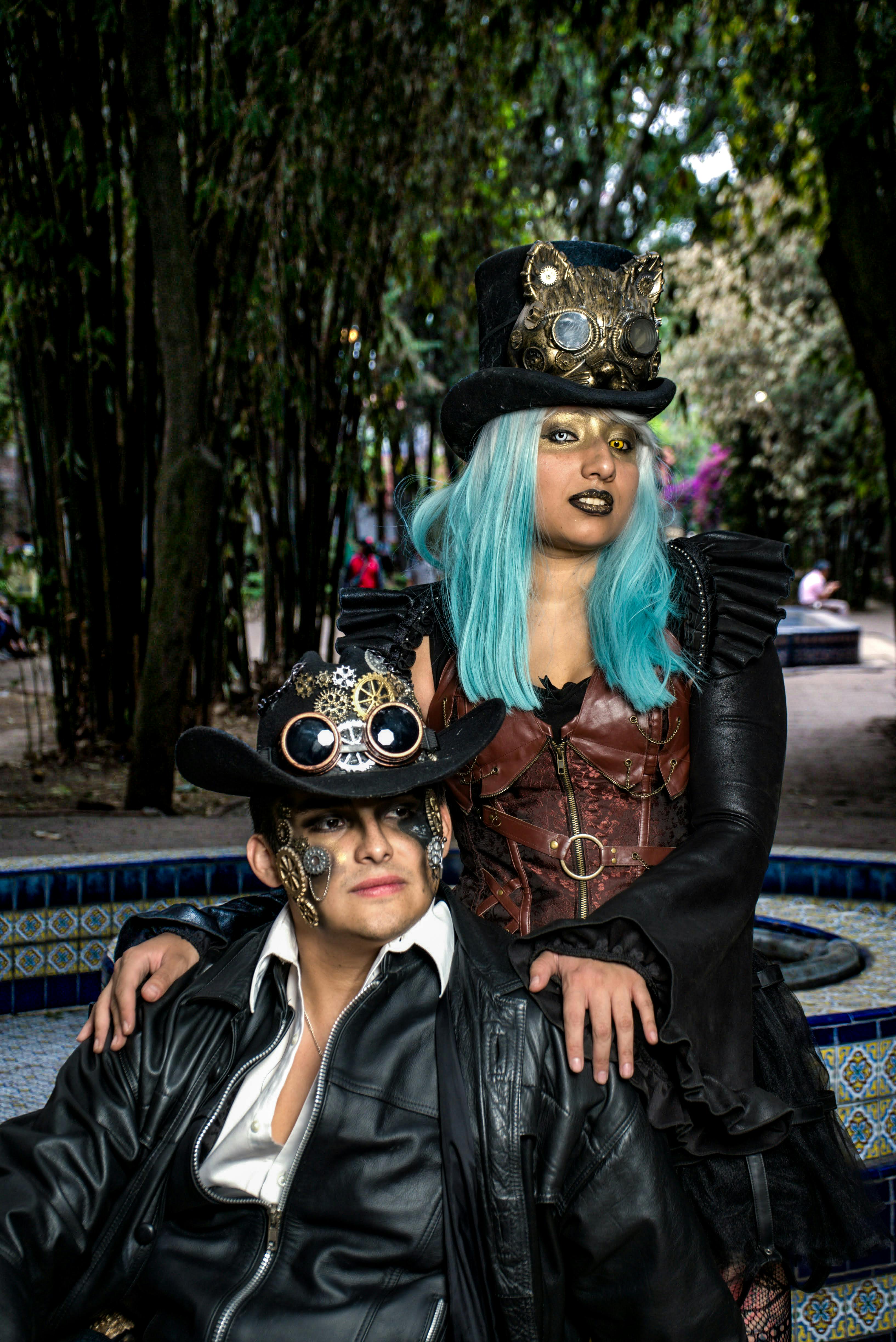 two steampunk cosplayers sitting on a fountain wall