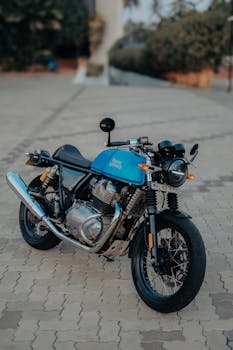 Photo of a parked blue Royal Enfield GT 650 motorcycle on city pavement.