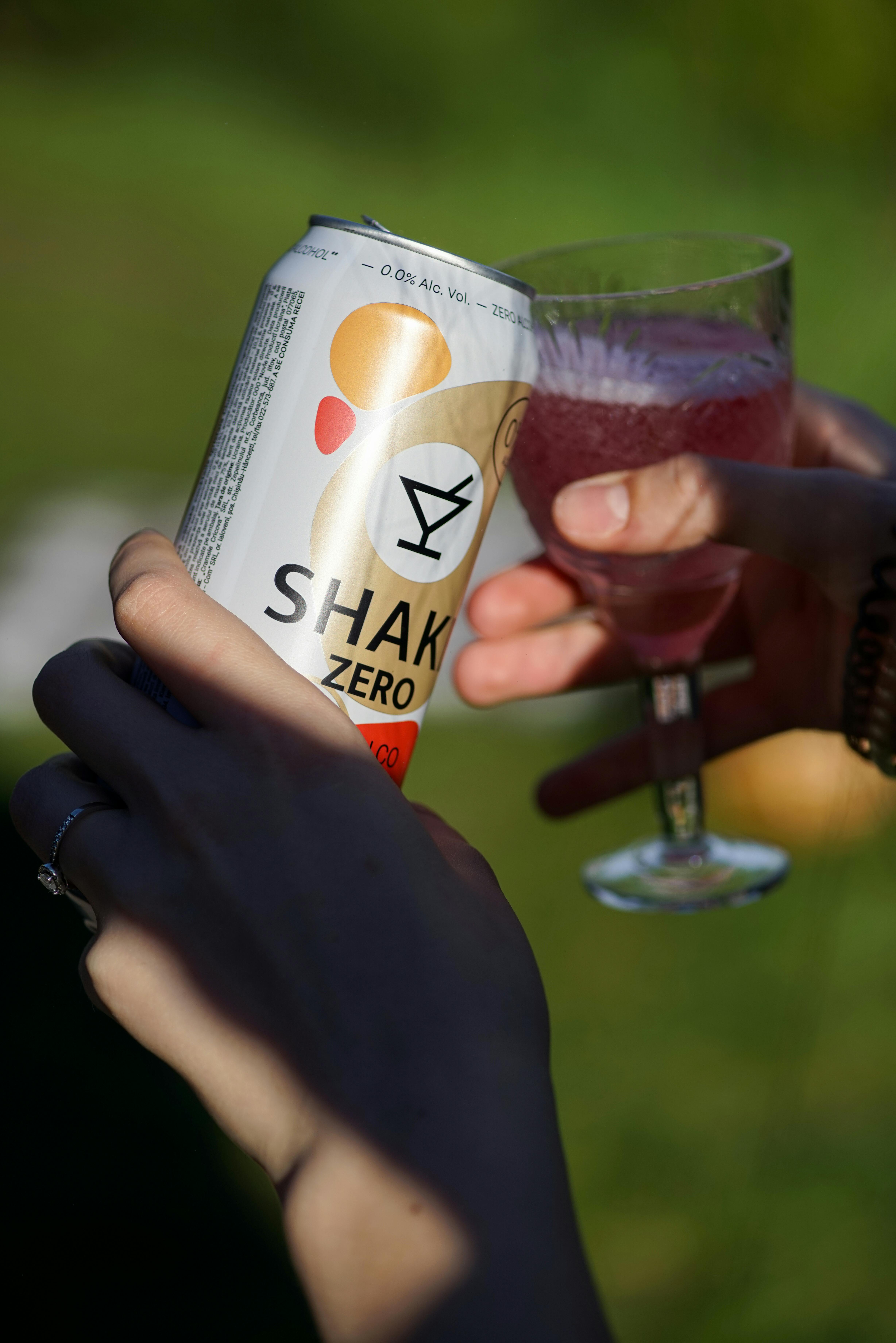 close up of a person pouring a nonalcoholic drink from a can into a glass