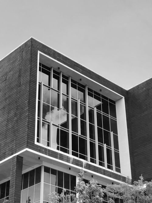 Free Black and white photo of a modern building facade with large windows in Singapore. Stock Photo