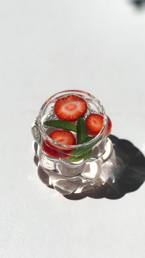 Free Glass of refreshing water with strawberry slices and mint leaves, ideal for detox drinks. Stock Photo