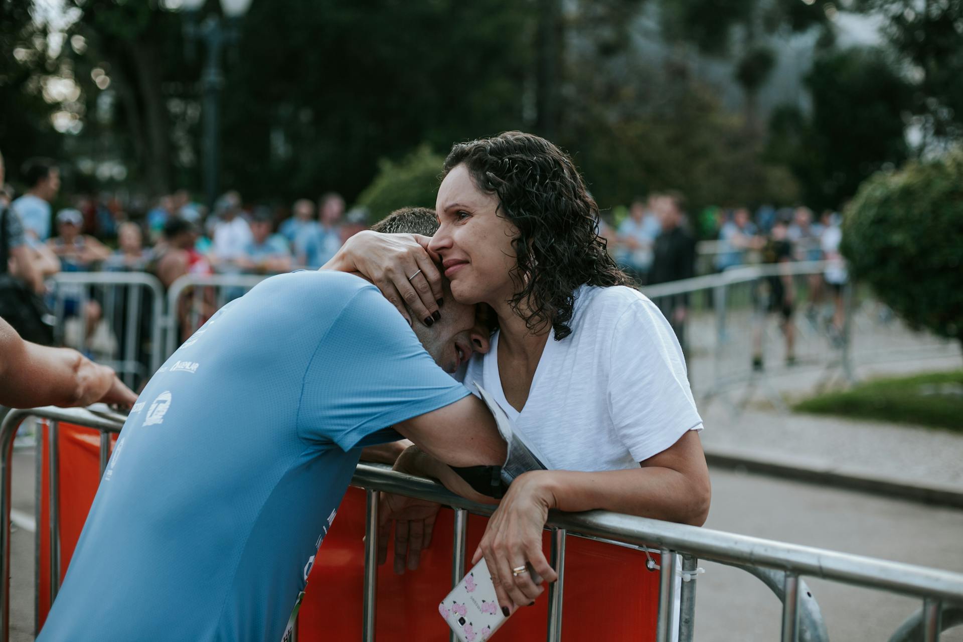 An emotional embrace between two adults at an outdoor event provides a touching moment.