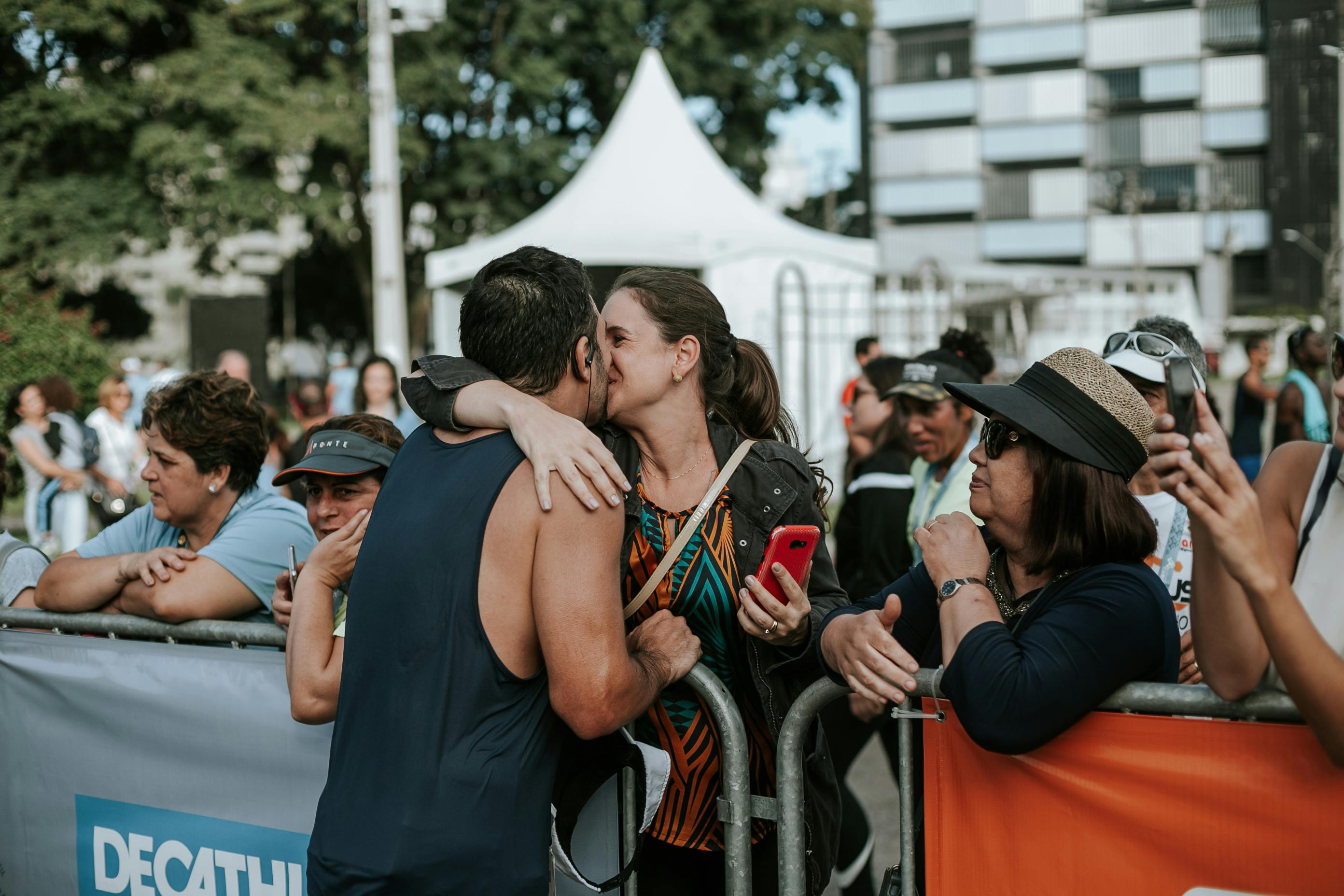 Woman lovingly kissing her partner after he's completed a race, celebrating his achievement together.