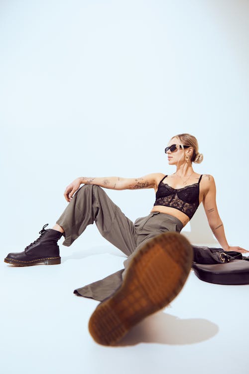 A woman in a bra top and pants sitting on the ground