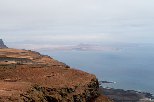 A view of the ocean and mountains from a cliff