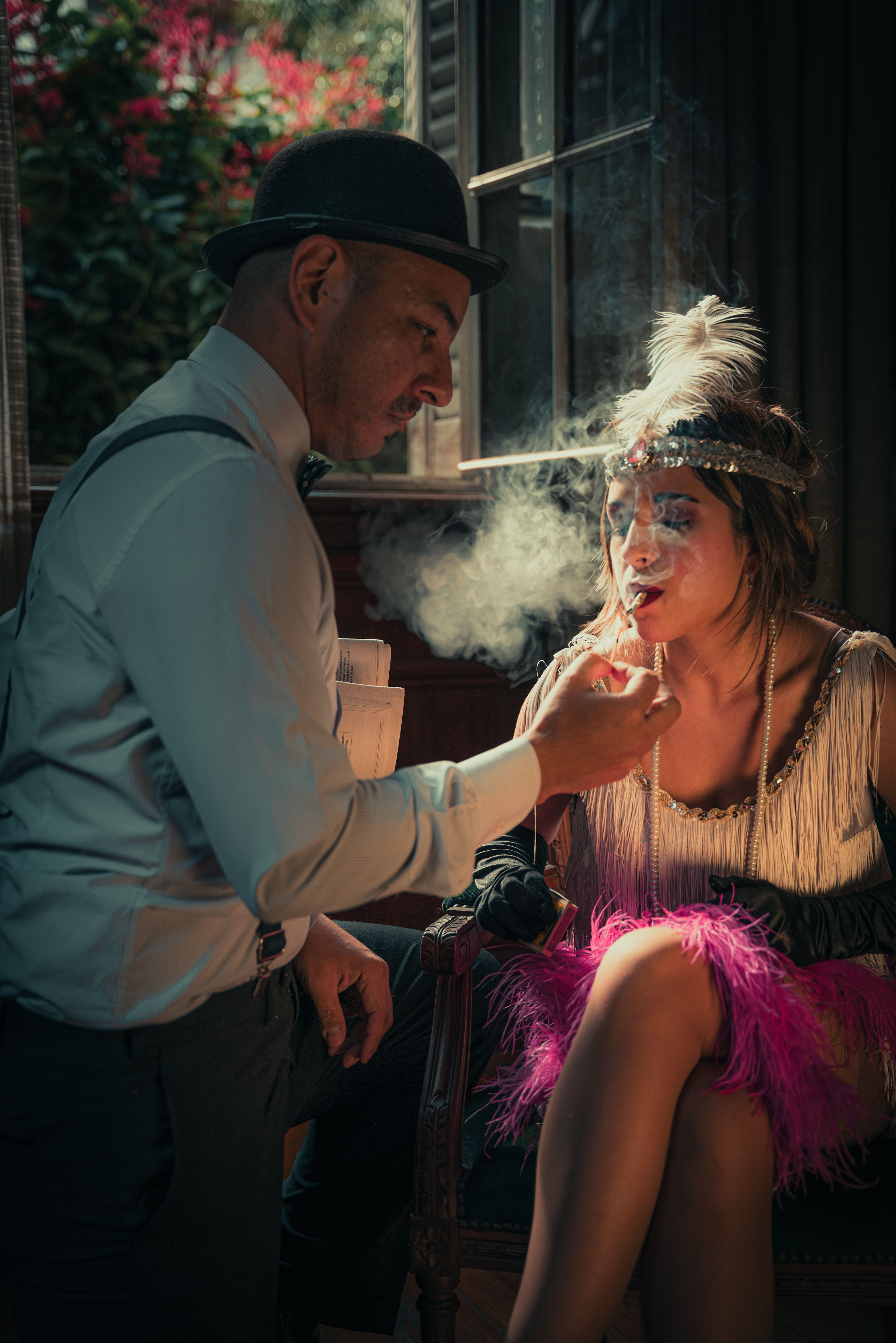 A vintage flapper scene with a woman smoking and a man in a bowler hat in a theatrical setting.