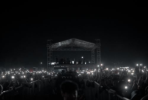 A crowd of people holding up their cell phones at night