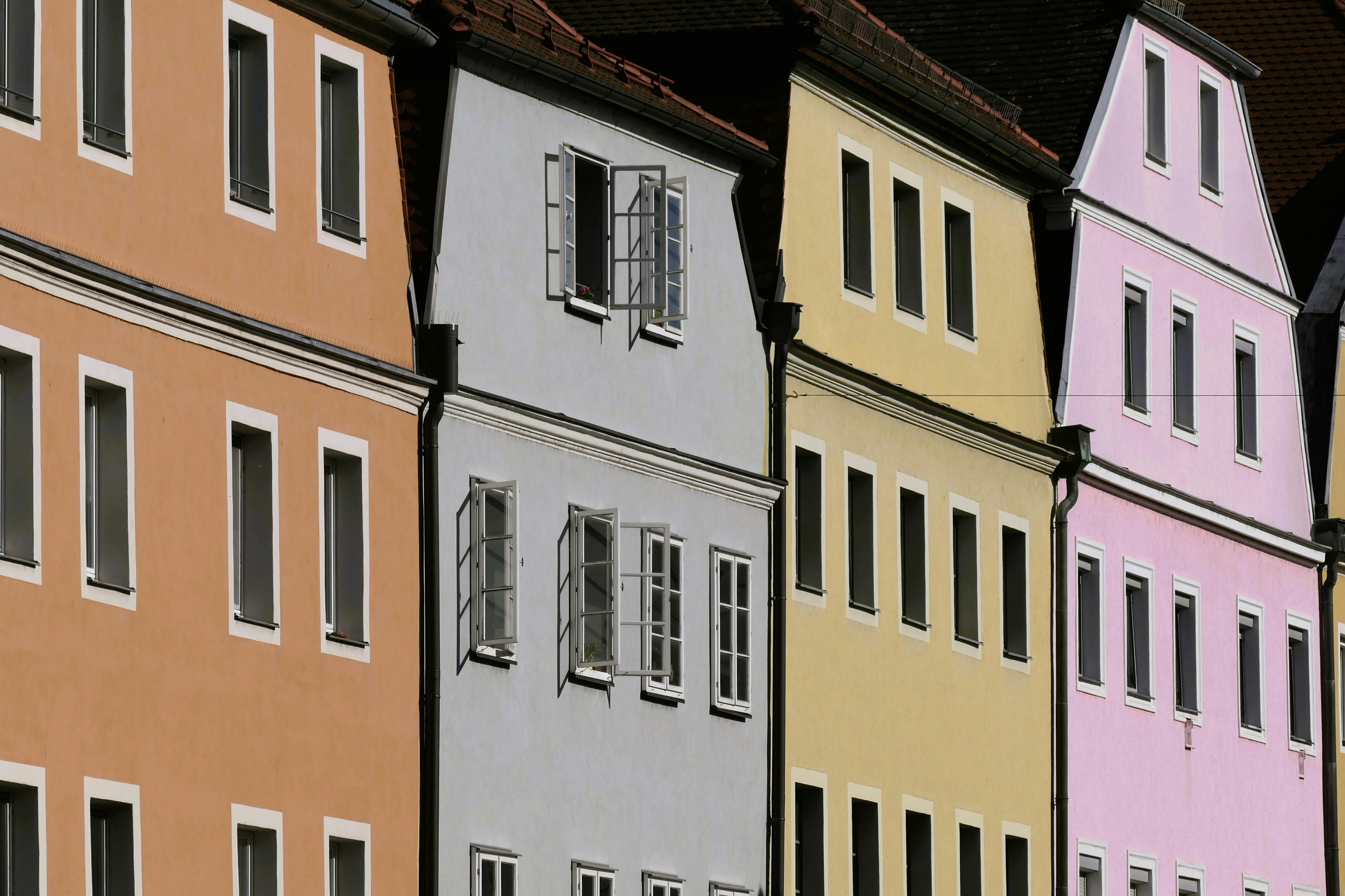 A vibrant row of pastel-colored buildings in Regensburg showcasing unique architecture.