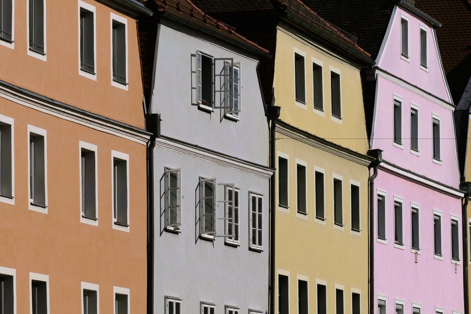 A vibrant row of pastel-colored buildings in Regensburg showcasing unique architecture.