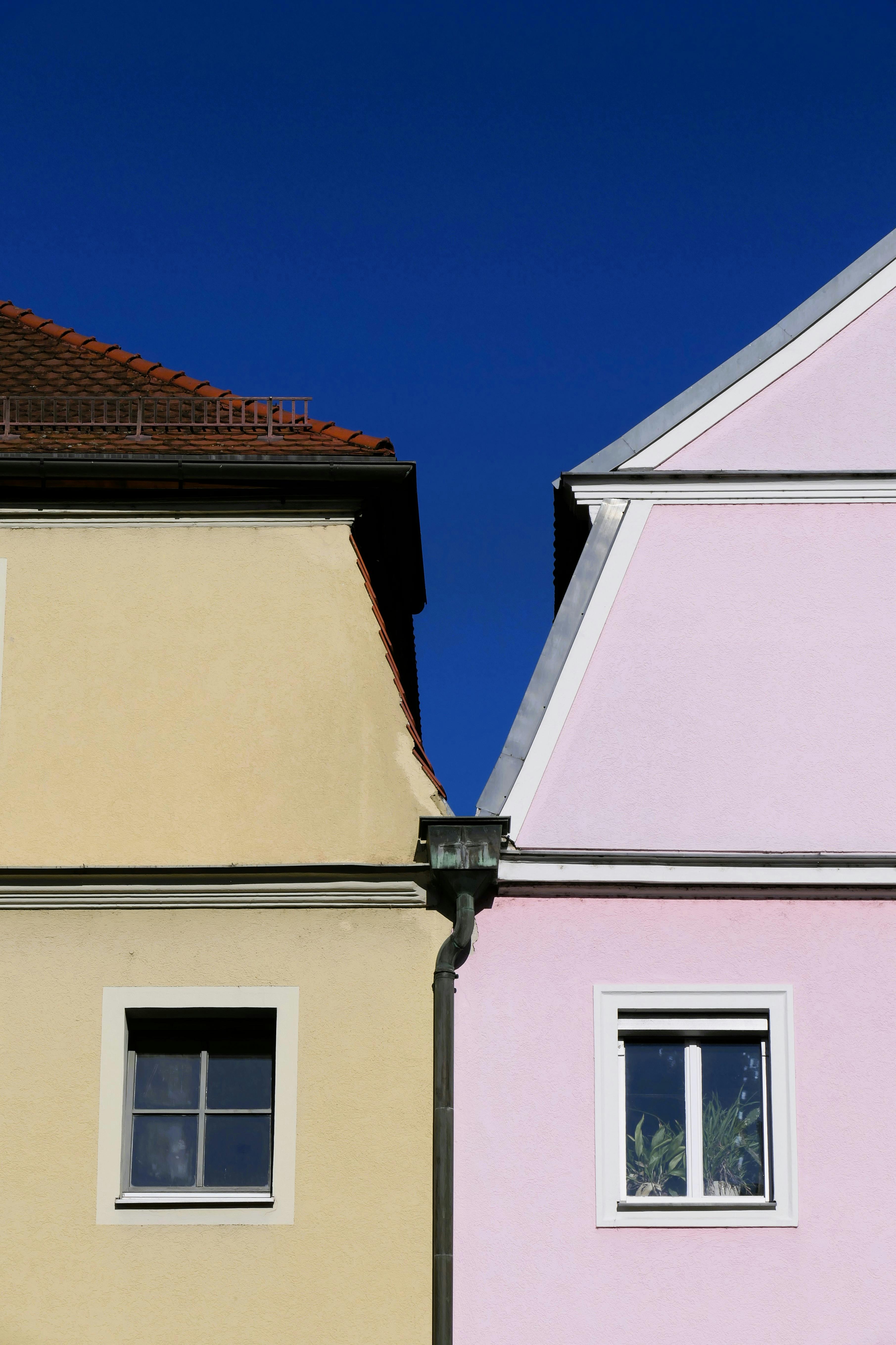 Charming townhouses in Regensburg with colorful facades and clear blue sky.