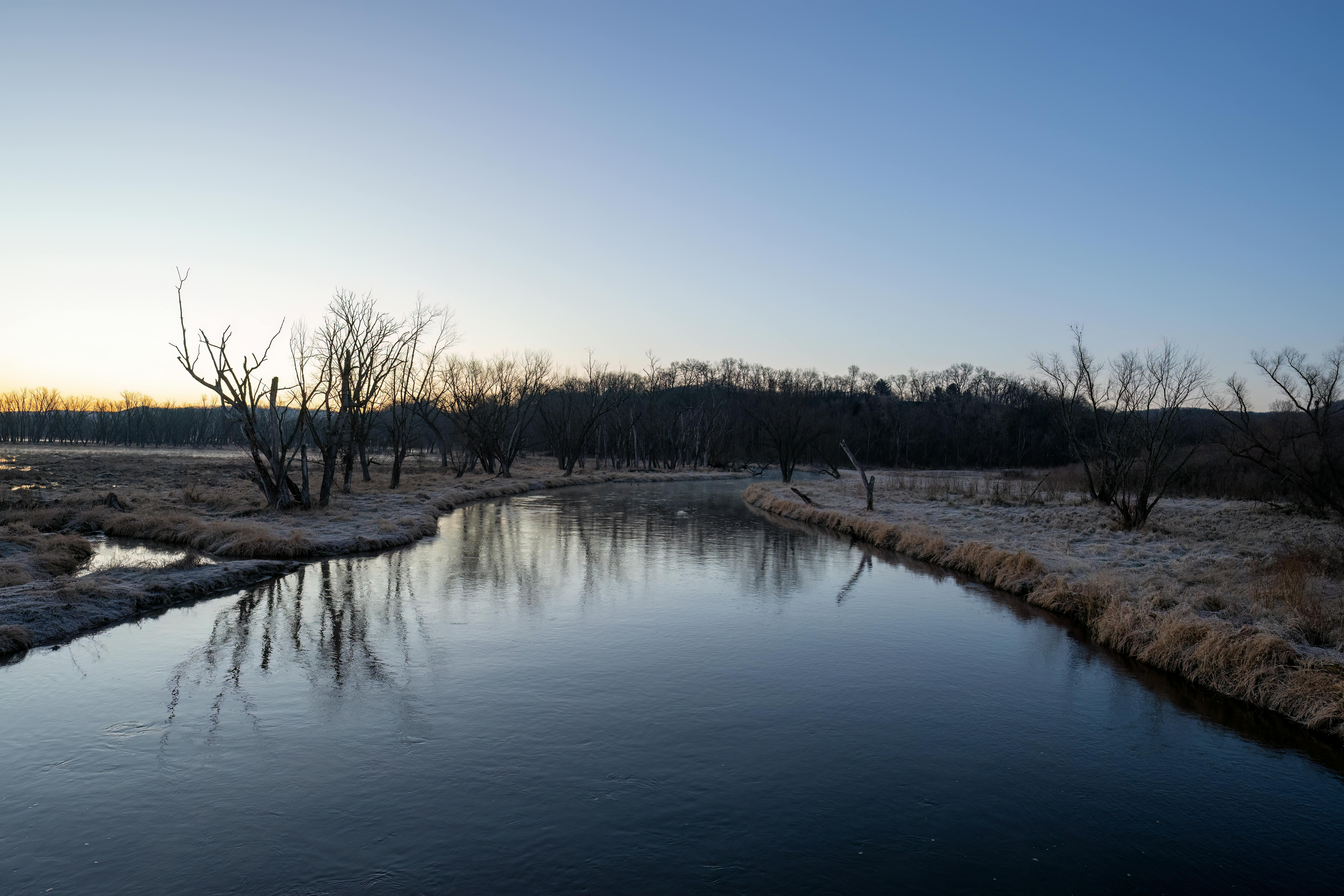 A tranquil river scene with frosty banks under a dawn sky in Tell, WI.