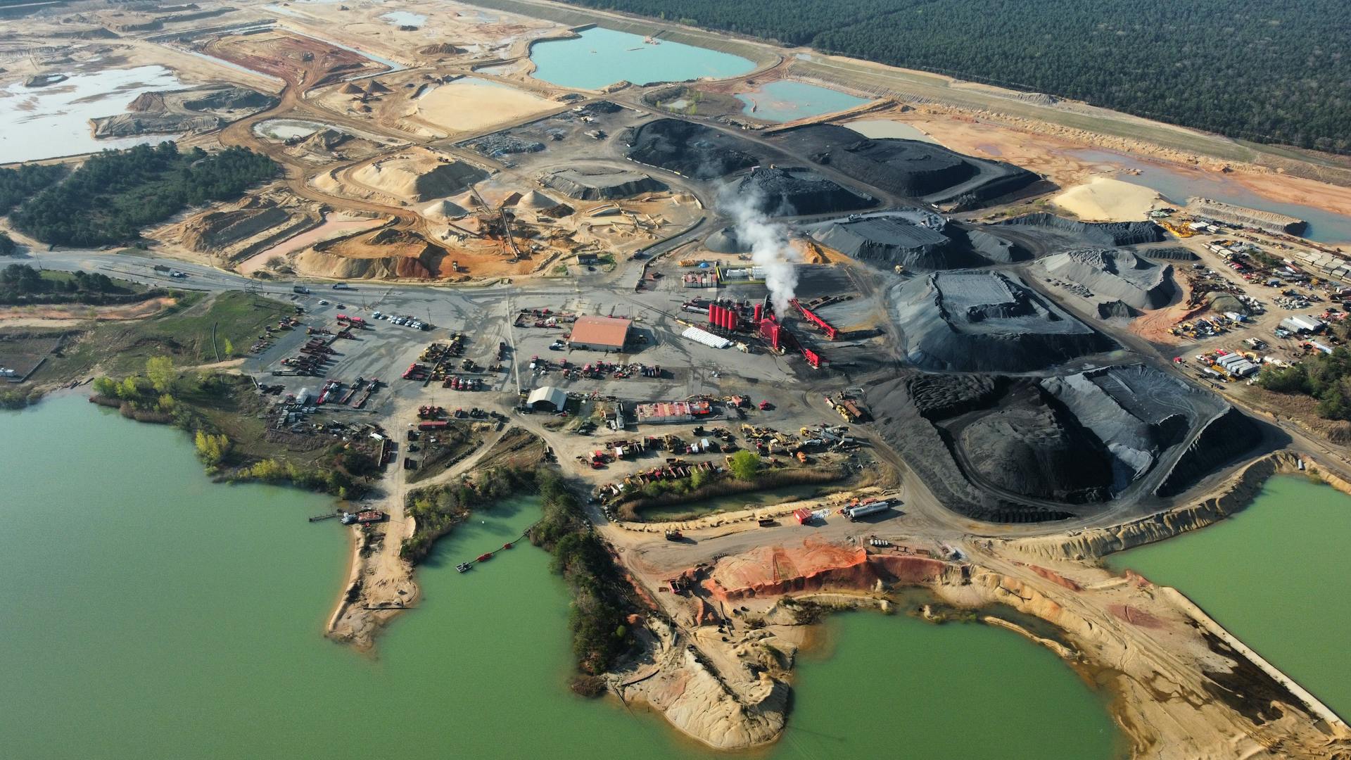 Birds eye view of a large mining operation with multiple excavation sites and ponds.