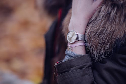 Woman in Brown Parka Jacket With Gold Round Analog Watch
