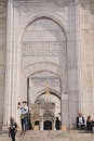A couple taking pictures in front of a large arch