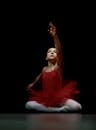 聚光灯下，身着红色芭蕾舞短裙的演员优雅地摆好姿势，动作尽显优雅