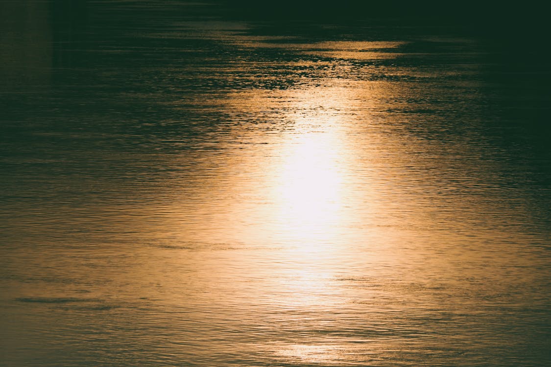 View of a Water Surface Reflecting Bright Sunset Light 