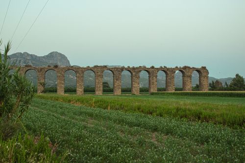 Free Explore the historic Aspendos aqueduct amid lush fields in Antalya, Turkey. Stock Photo