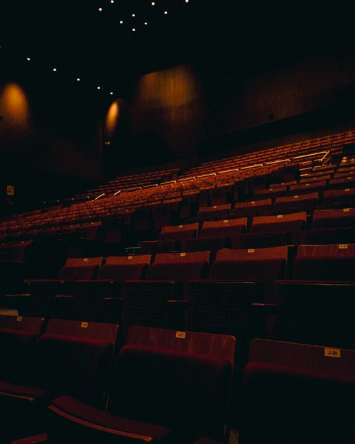 Free Dark interior of an empty theater with rows of seats, creating a moody atmosphere. Stock Photo