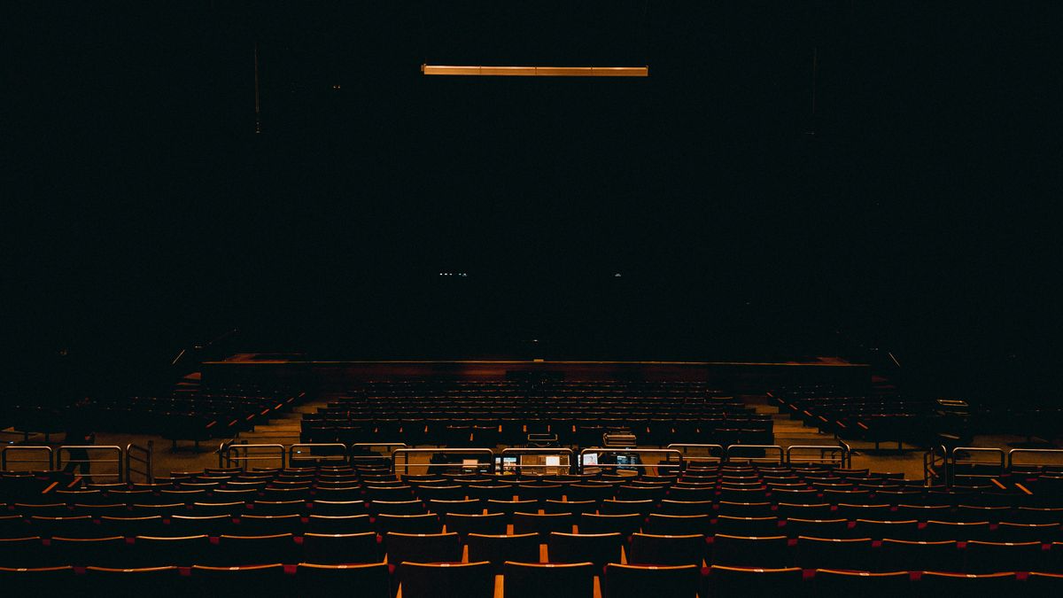 Empty dark auditorium, representing the typical one-hour webinar experience