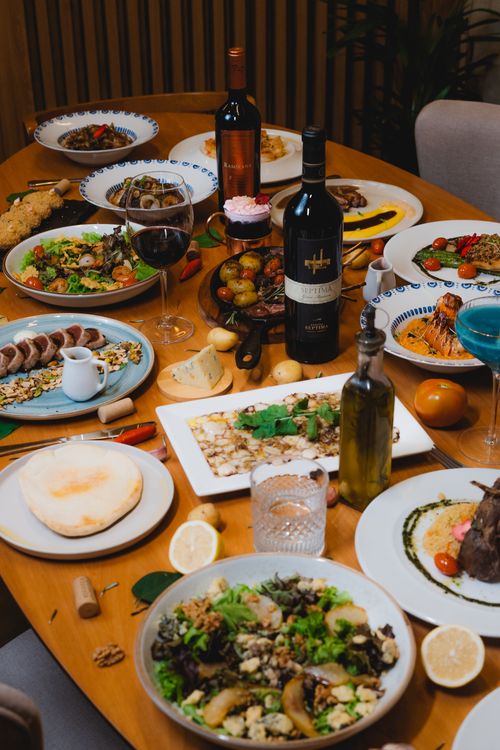 Free A luxurious dining setup with diverse dishes, salad, wine, and an inviting ambiance. Stock Photo