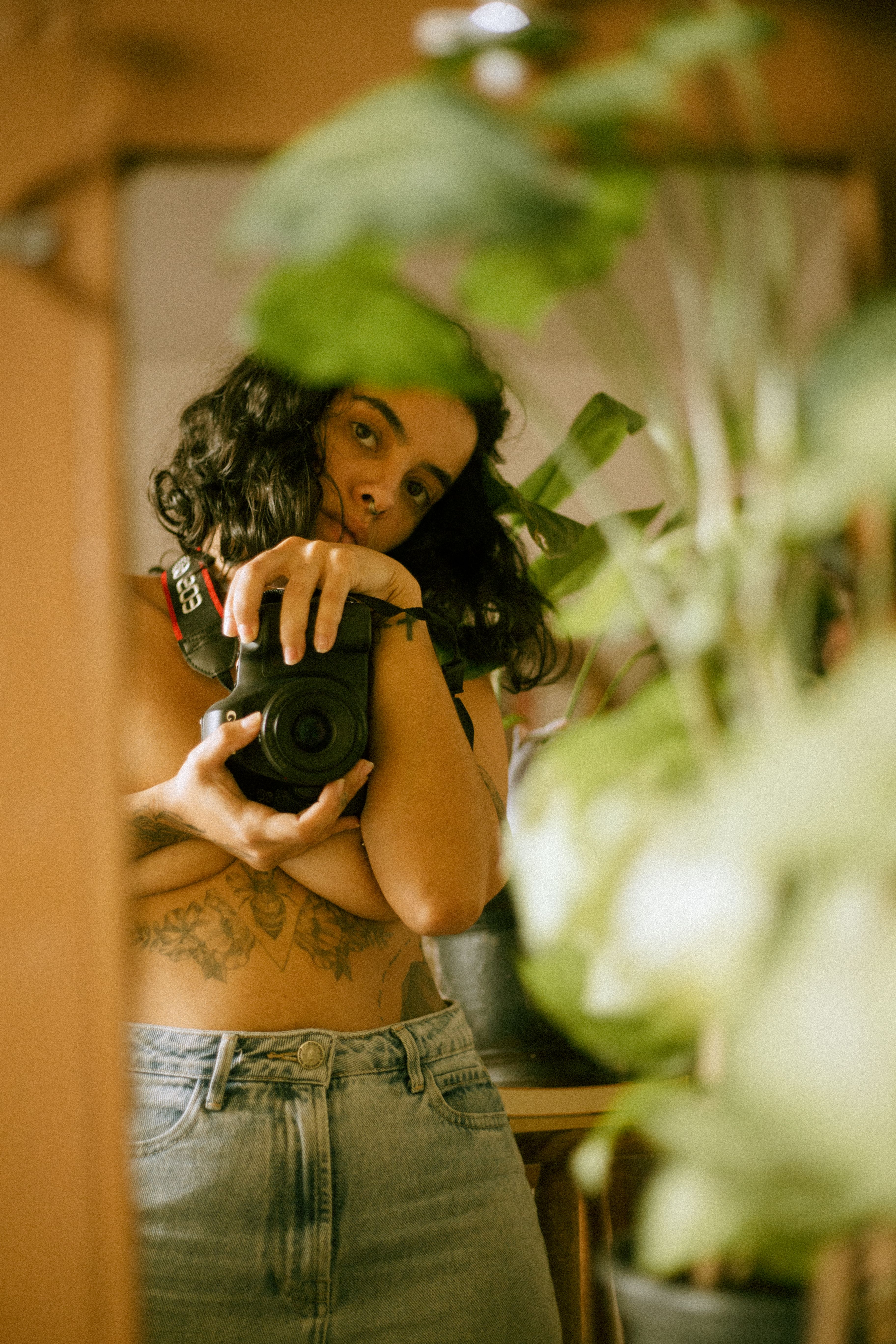 A woman capturing her reflection with a camera in an artistic setting.