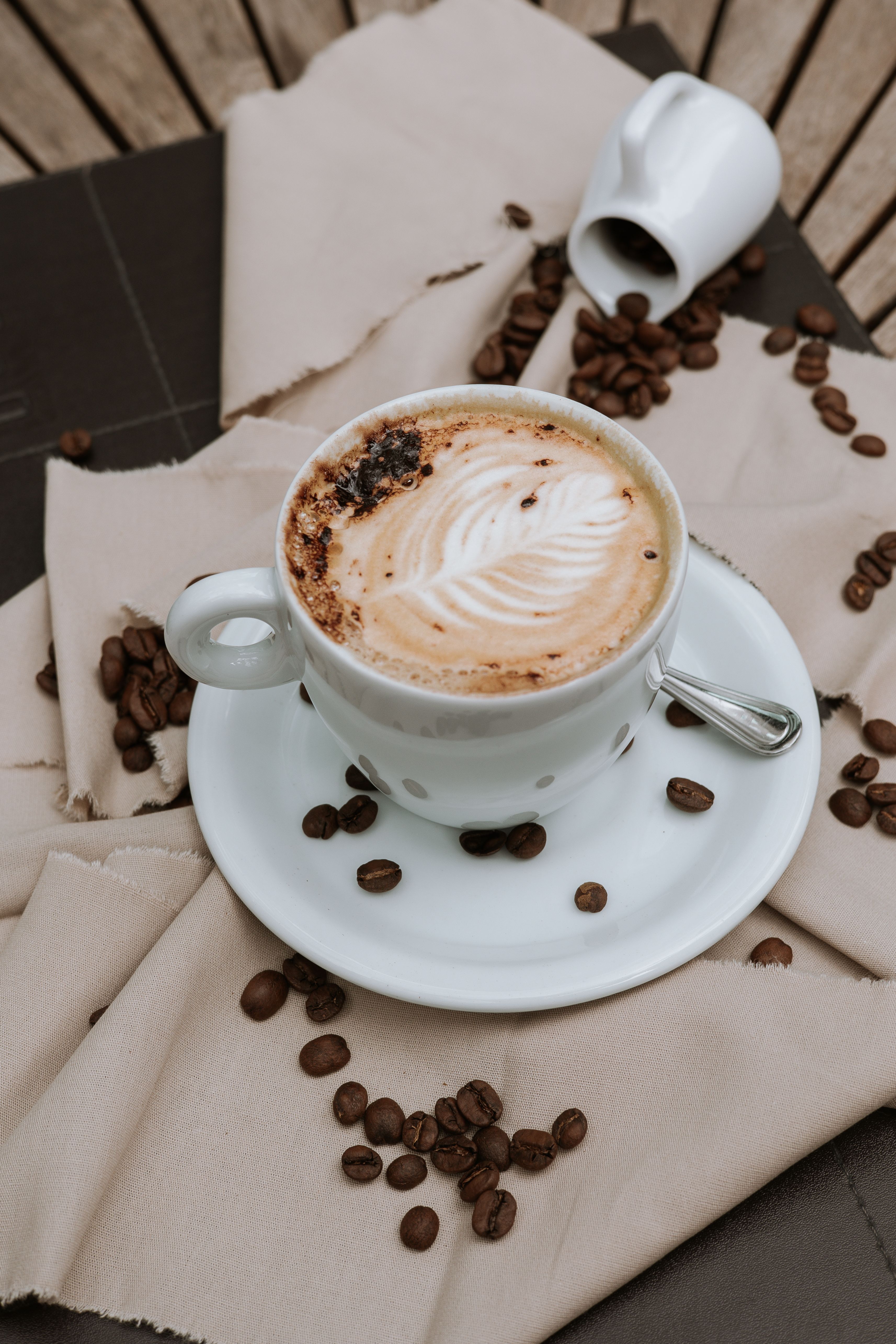 A cappuccino and a bag of coffee in warm morning light