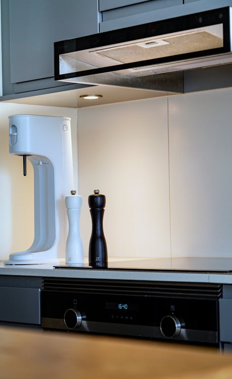 A kitchen with a white stove and a coffee maker