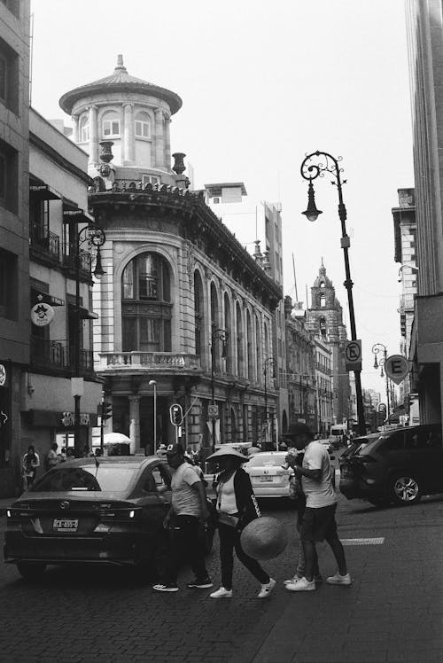 A black and white photo of people walking on the street