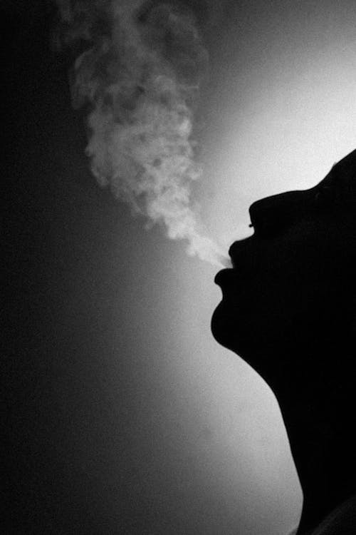 A black and white photo of a person smoking