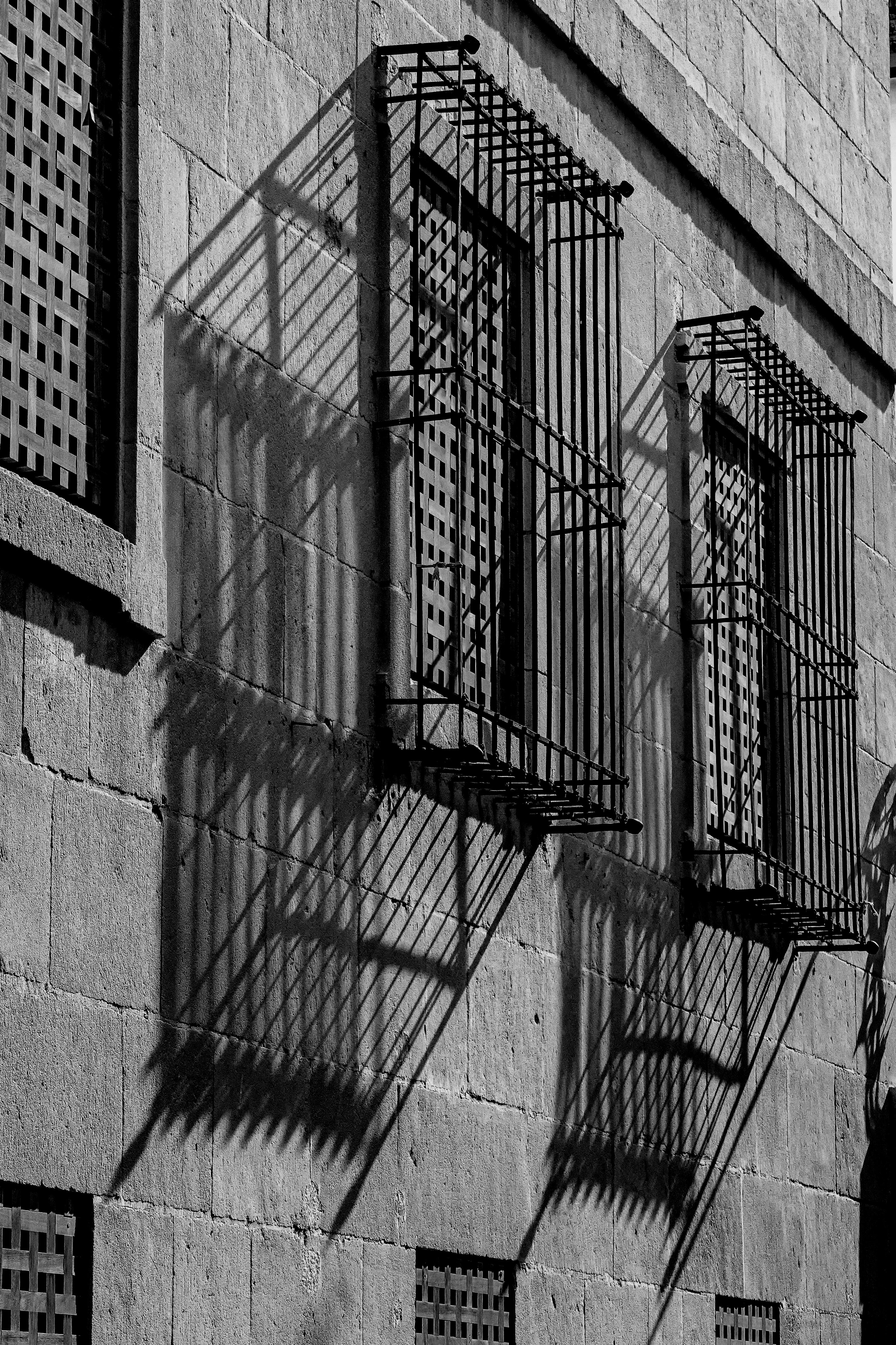 black and white photo of a stone wall with window bars