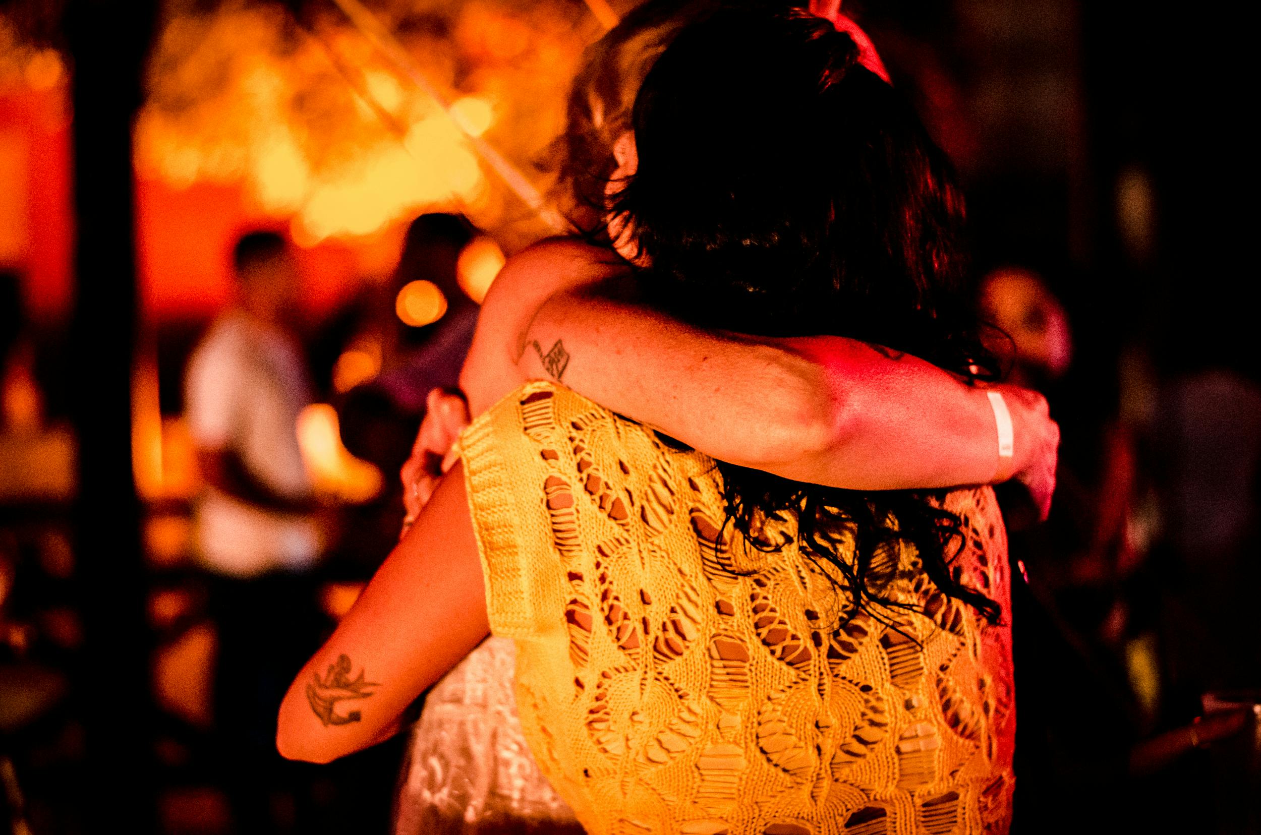 people hugging by a campfire