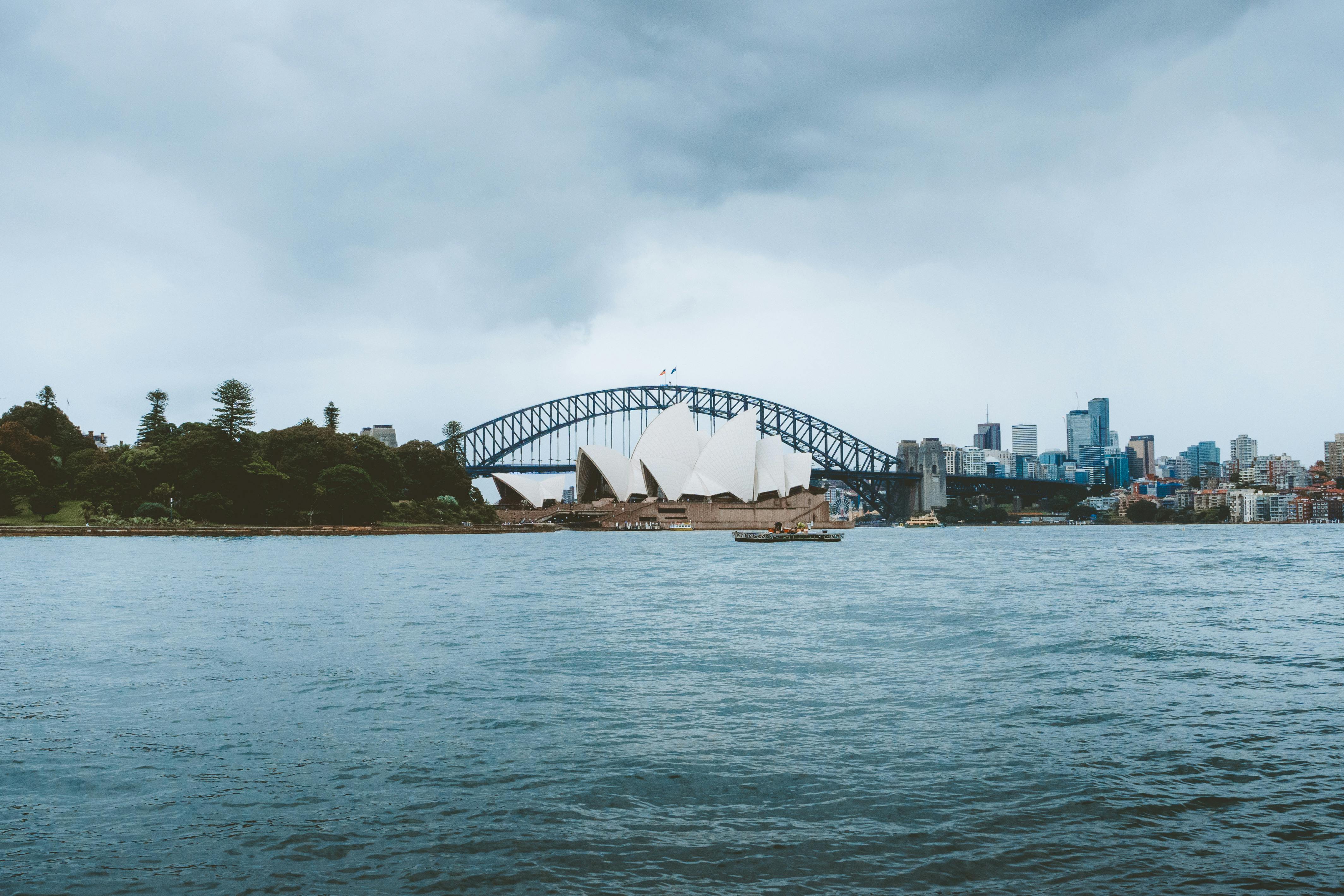 Stunning view of Sydney Opera House and Harbor Bridge on a cloudy day.