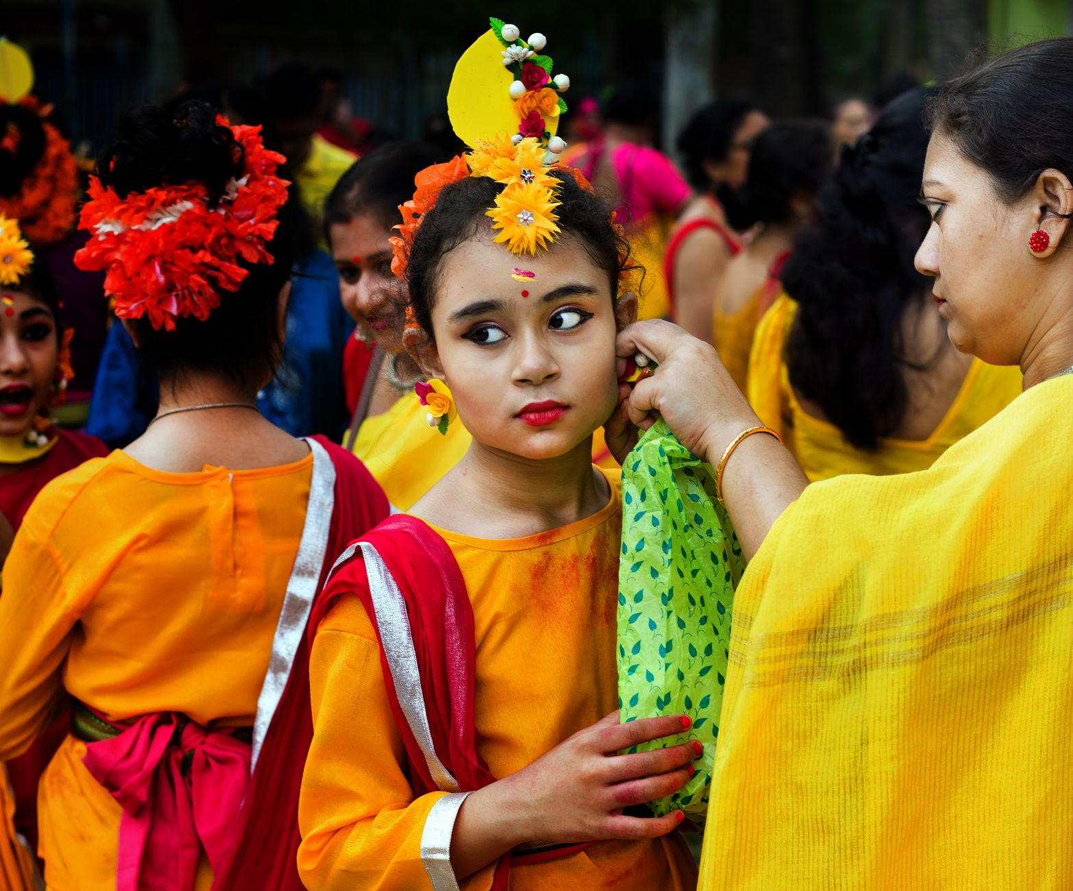 Vibrant traditional festival with girls in colorful attire, showcasing cultural heritage.