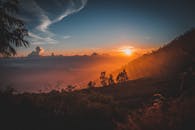 印度尼西亚郁郁葱葱的山丘上，日落景色如田园诗般，地平线风景优美，天空充满戏剧性