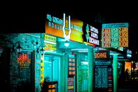Night view of a brightly lit storefront and currency exchange signs in Batumi, Georgia.