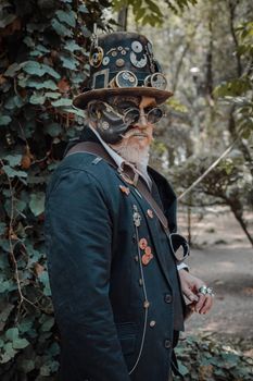 Portrait of a man in steampunk attire standing outdoors, surrounded by nature.