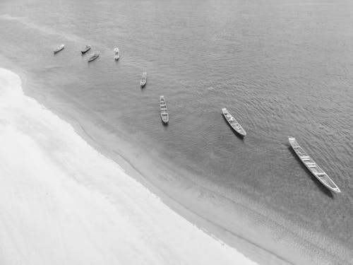 A black and white photo of boats on the beach