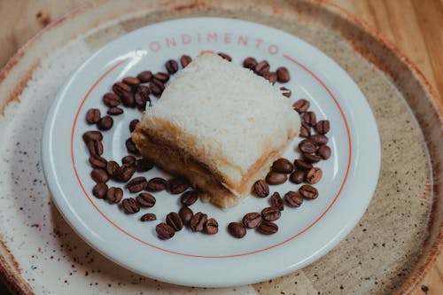 A plate with a sandwich and coffee beans on it