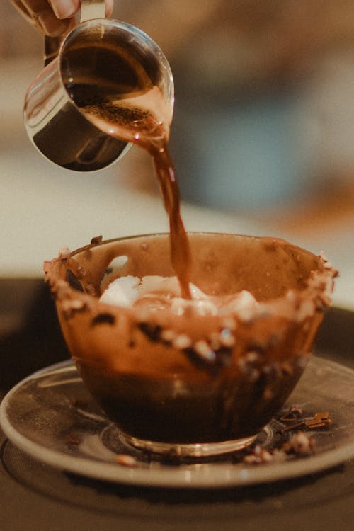 A person pouring chocolate into a cup