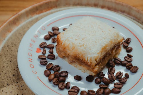 A plate with a piece of cake and coffee beans