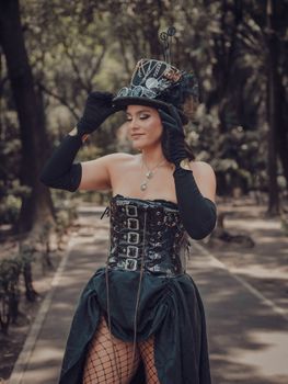 Woman in steampunk costume posing outdoors, showcasing vintage style corset and accessories.
