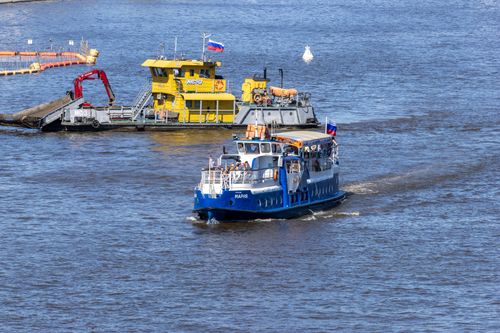 Free A colorful scene of industrial water transport with boats navigating a bustling waterway. Stock Photo