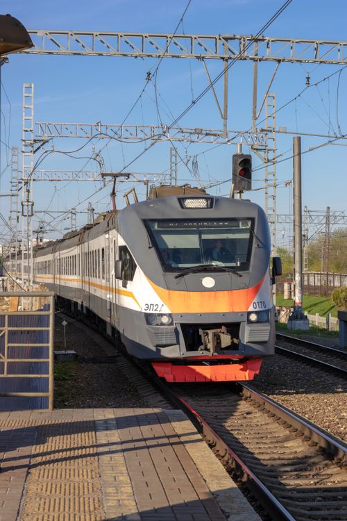 Free A commuter train approaching a platform on a clear day, showcasing public transportation infrastructure. Stock Photo