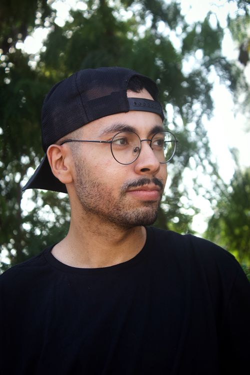 Free Casual portrait of a man with glasses and cap in a natural outdoor setting. Stock Photo