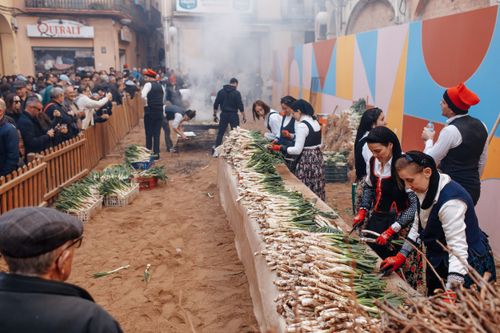 Free People in traditional clothing grill vegetables at a vibrant street festival. Stock Photo