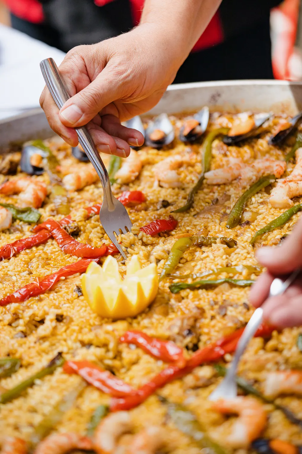 Convives partageant une grande paella aux fruits de mer