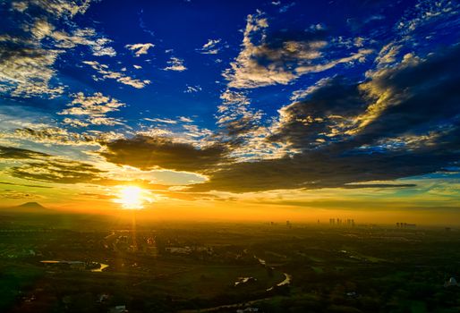 A breathtaking aerial view of a vibrant sunset over Banten, Indonesia with a dramatic sky.